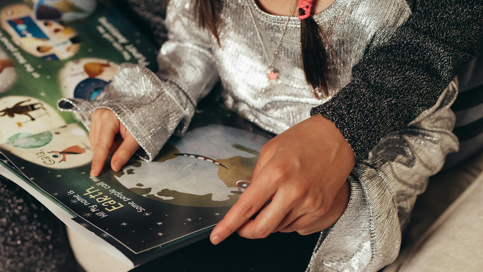 Dorosły pomaga dziecku czytać kolorową książkę w domu