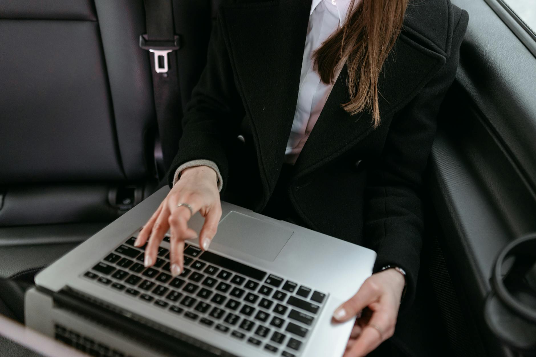 Bizneswoman w samochodzie pracuje na laptopie nad analizą danych