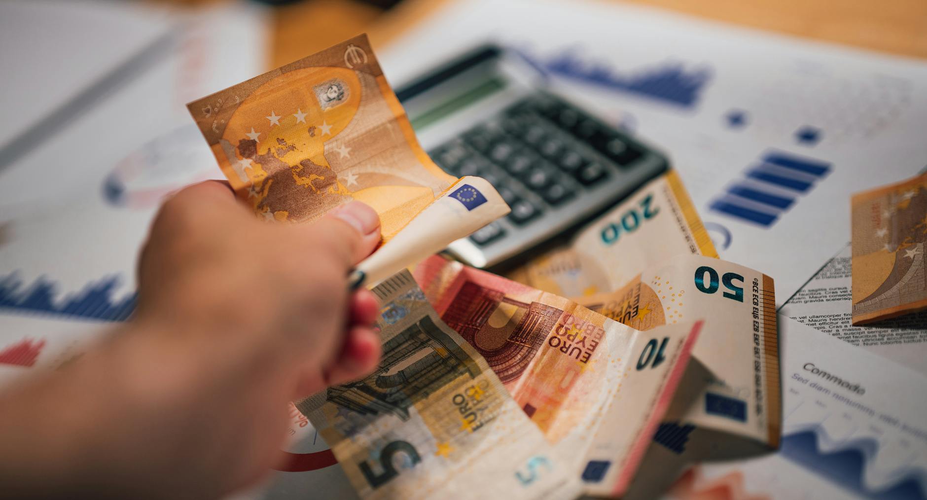 Eurobanknoty na dokumentach finansowych obok kalkulatora