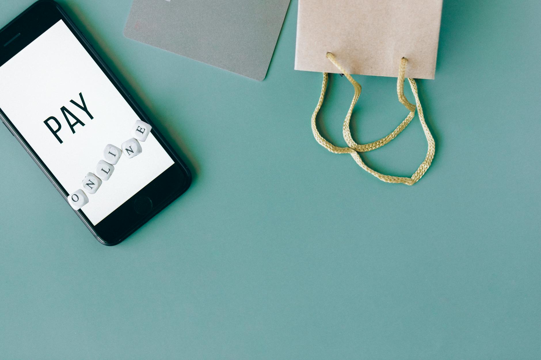 Smartfon, karta kredytowa i torba zakupowa symbolizujące płatności online