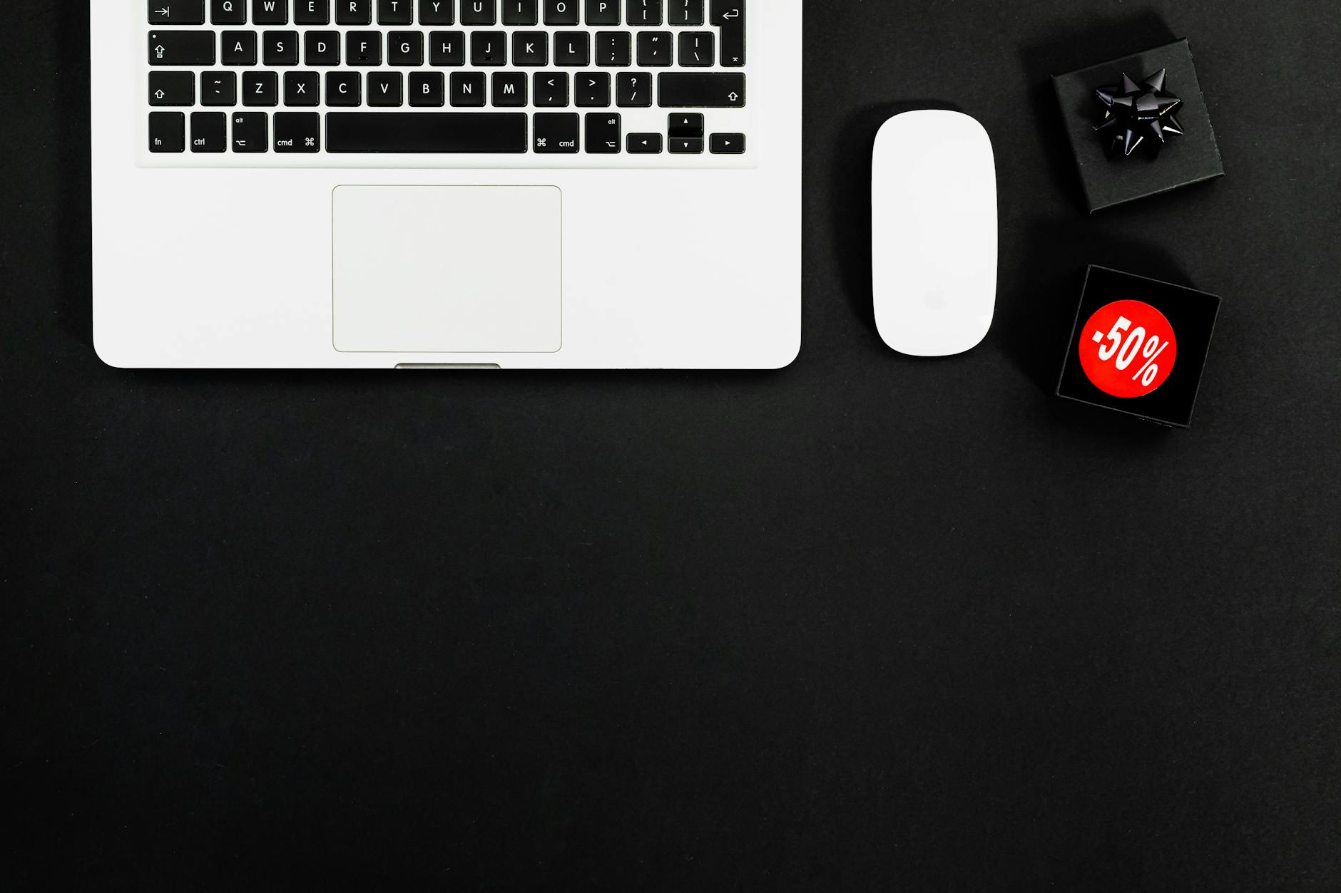 Laptop i produkty z metkami wyprzedaży 50 procent na jasnym tle