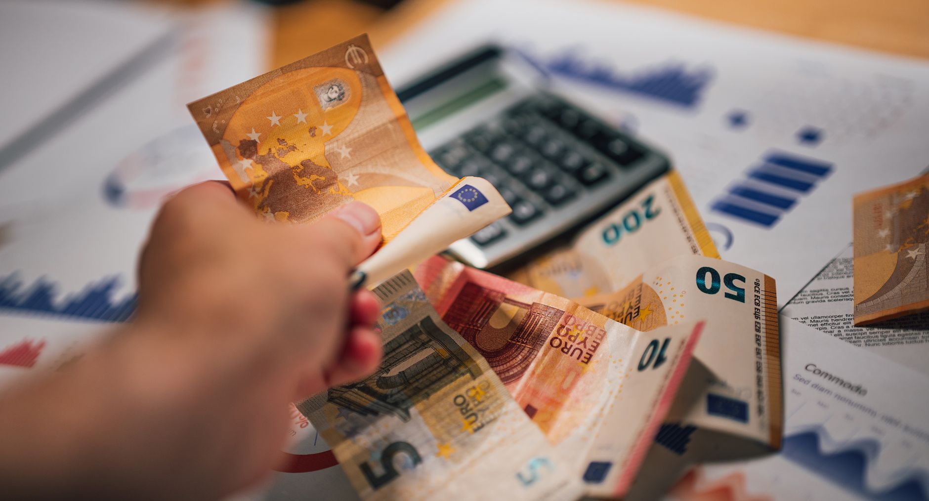 Banknoty euro, dokumenty finansowe i kalkulator przy planowaniu cashbacku