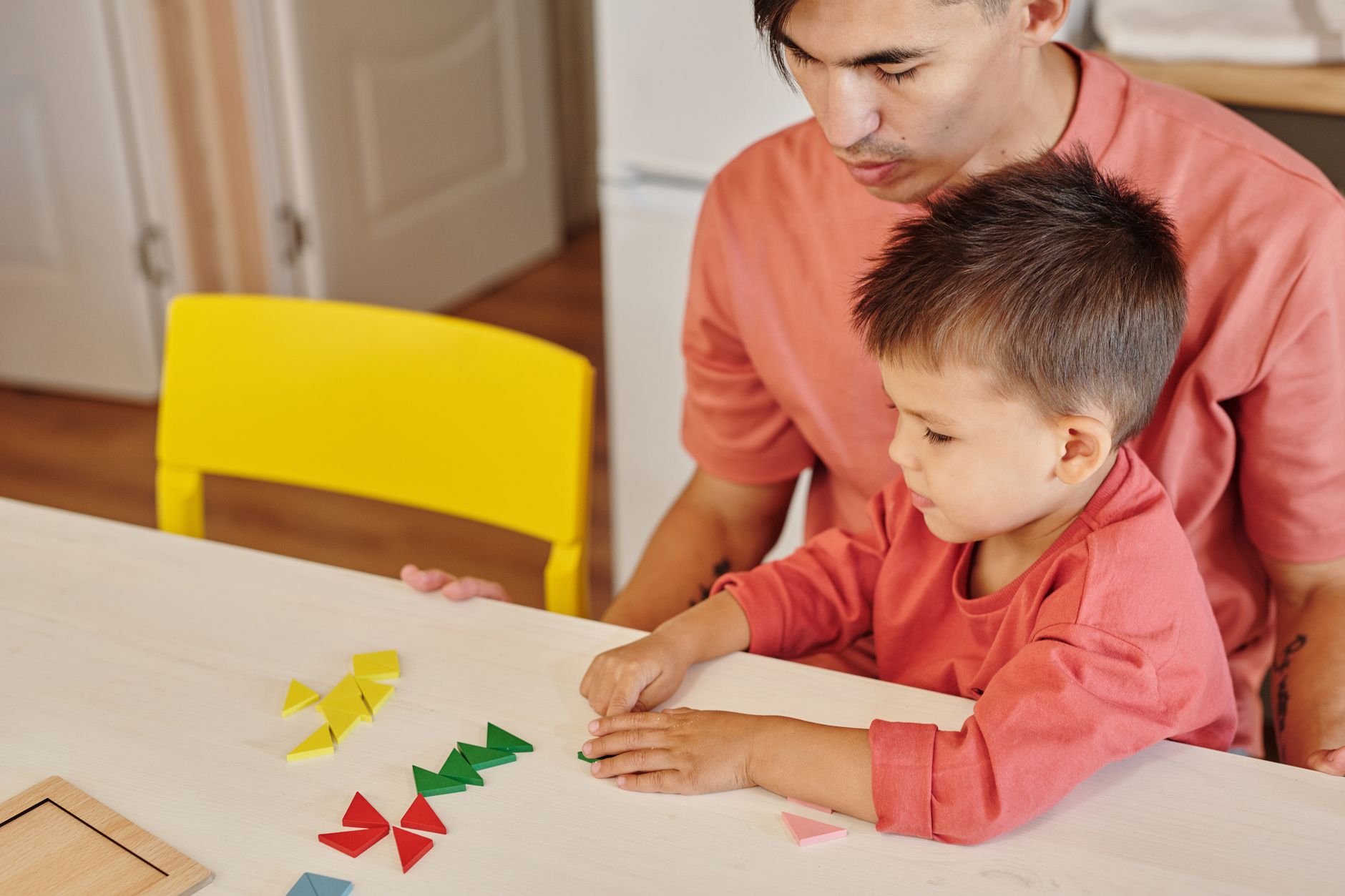Tata i syn bawią się kolorowymi edukacyjnymi kształtami w domu Tata i syn bawią się kolorowymi edukacyjnymi kształtami w domu